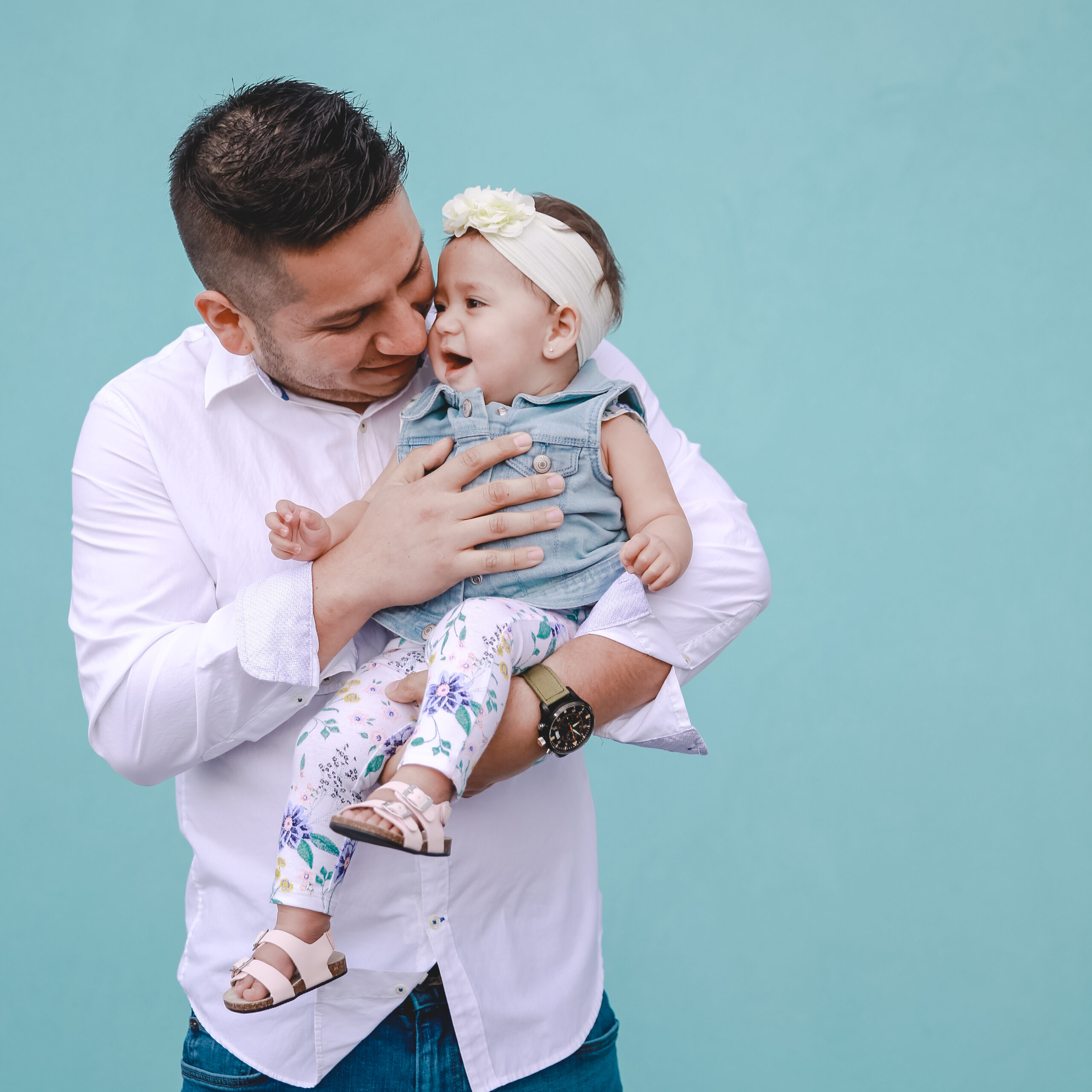 baby with sandals held by her father