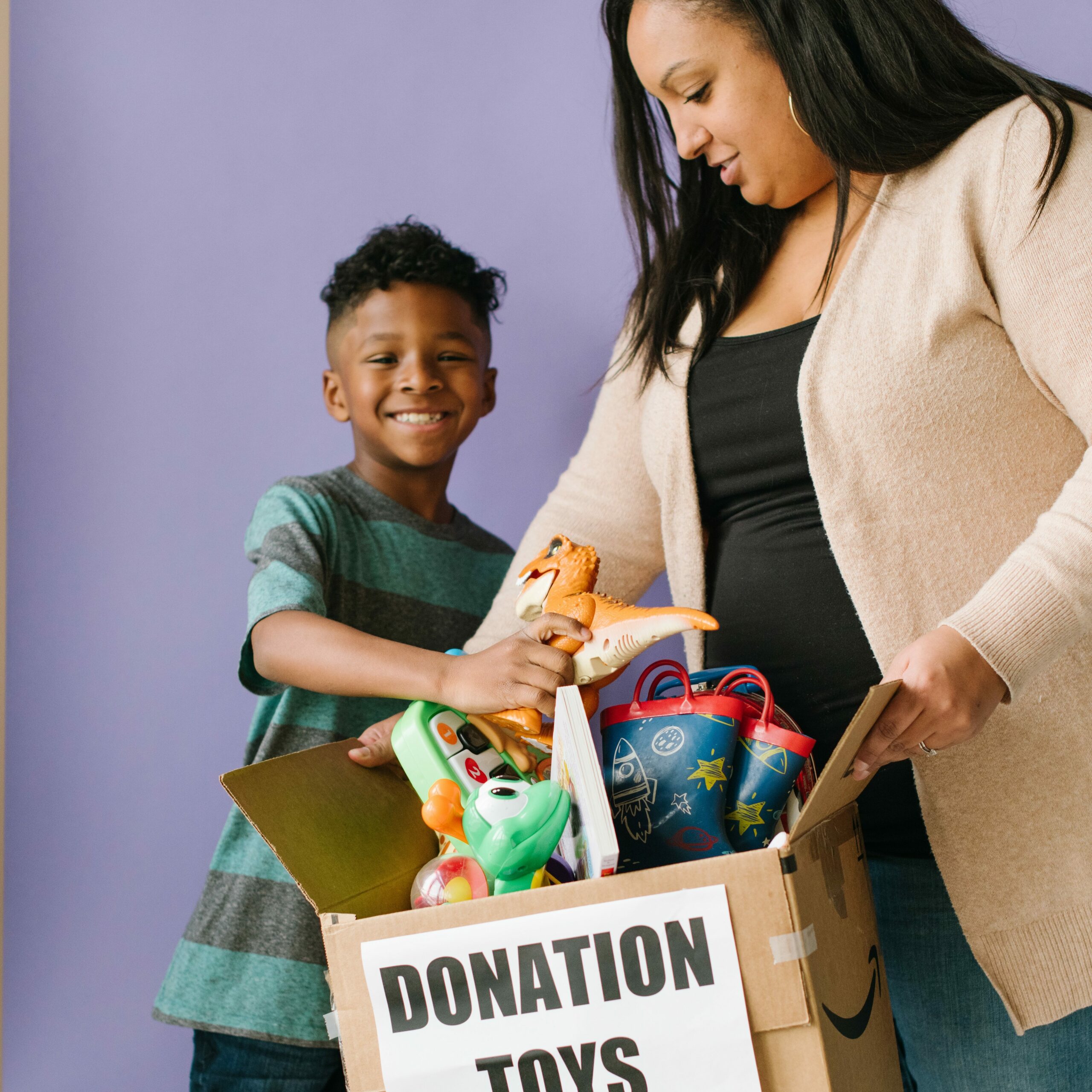 mother and son with a donation box for kid to kid