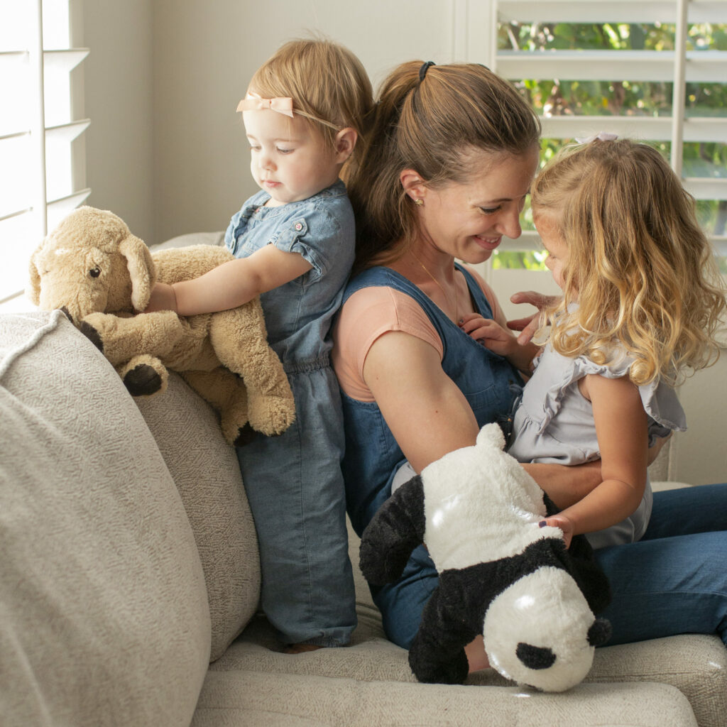 mother sitting on couch with her two daughters