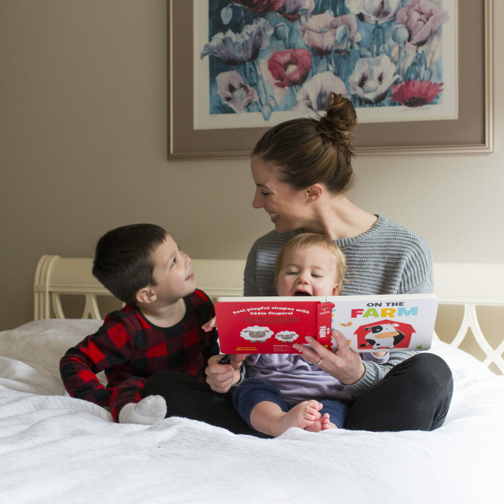 Mother sitting in bed reading to her two children