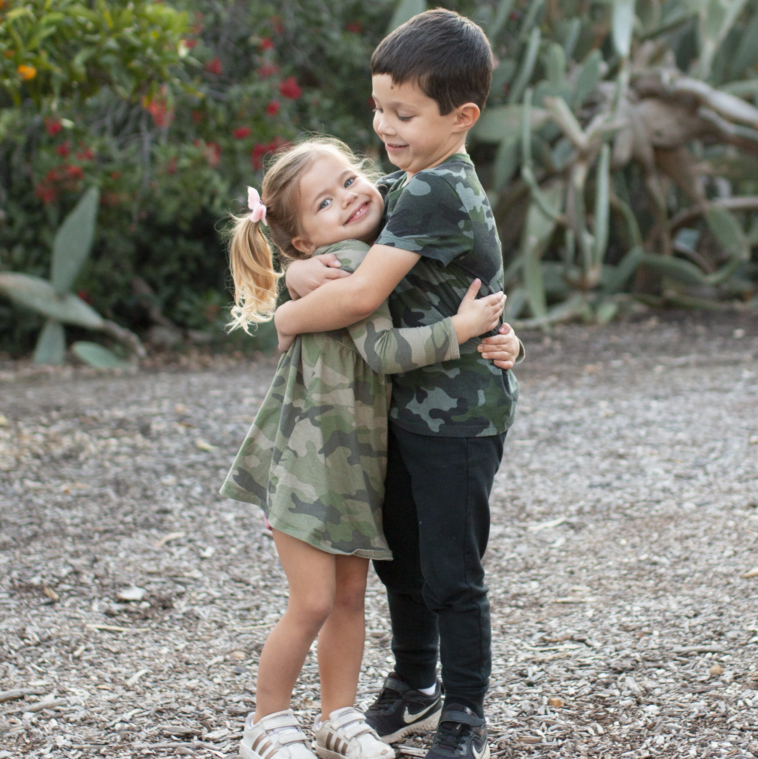 a boy and girl hugging outside in clothes from kid to kid