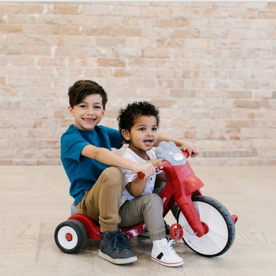 two boys riding a tricycle