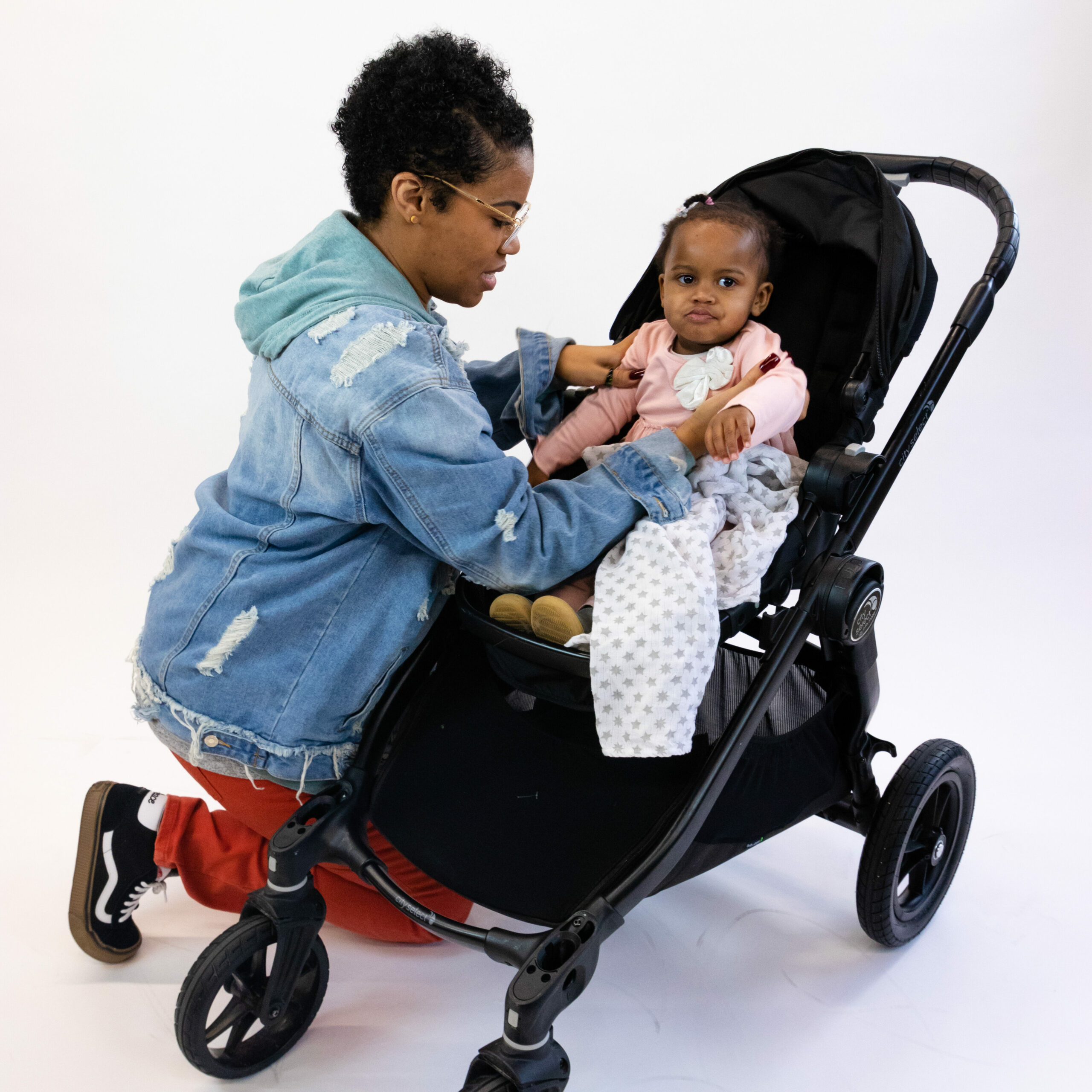 Mother setting her child in a full size stroller from kid to kid