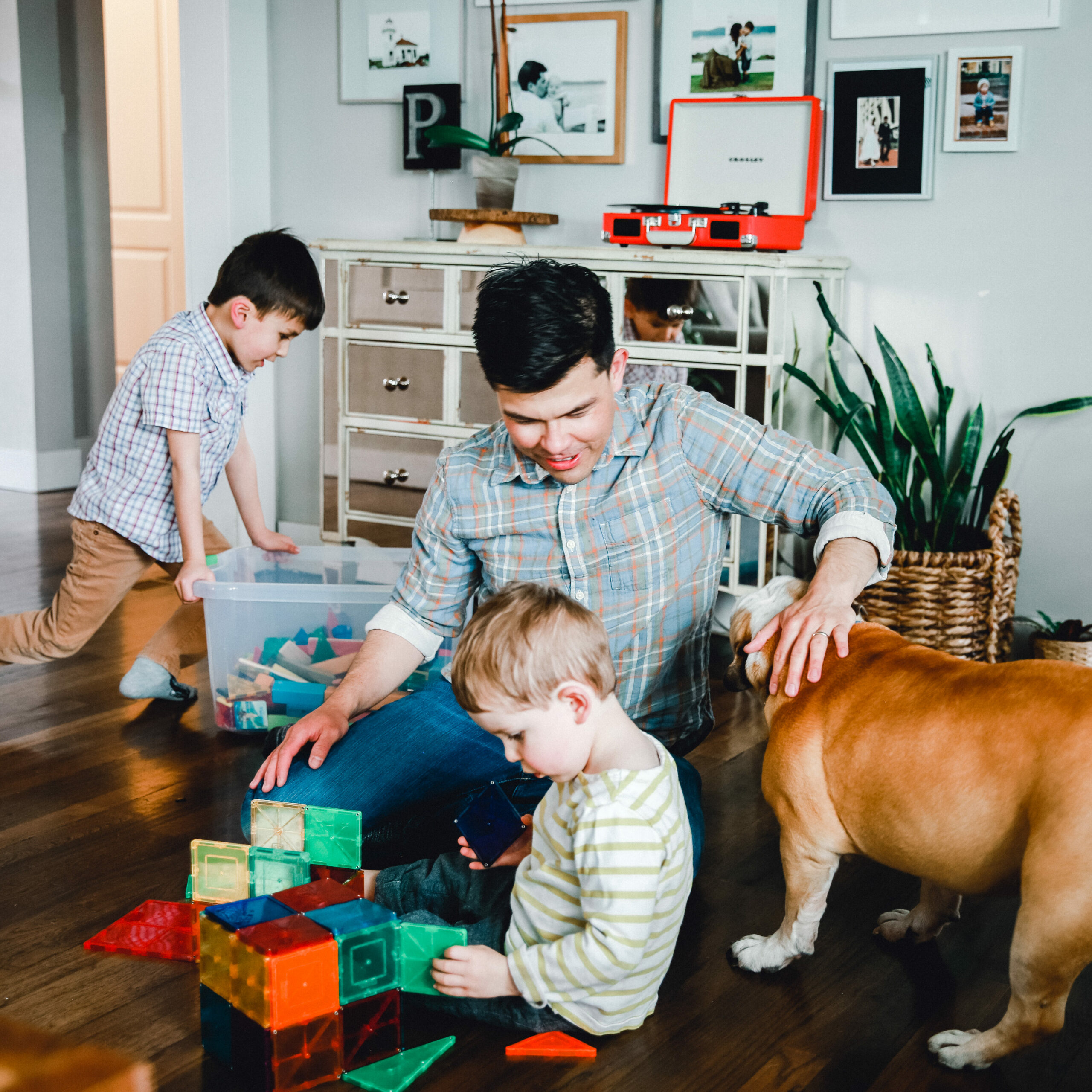 Dad with his two sons and the family dog with building blocks
