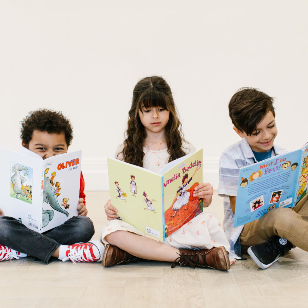 three children reading books from kid to kid