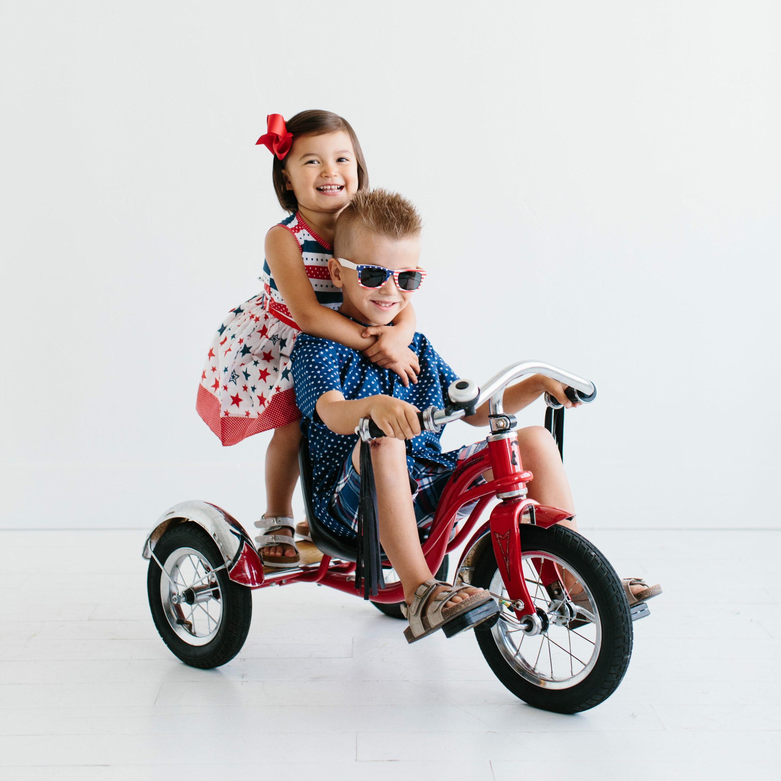 a boy and girl on a tricycle