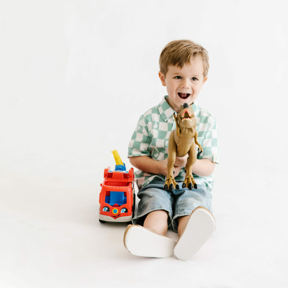 boy holding a toy dinosaur from kid to kid